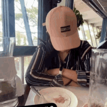 a woman wearing a hat that says off the grid sits at a table