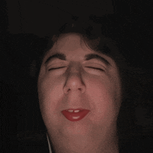 a close up of a person making a funny face with their eyes closed