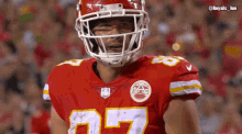 a football player wearing a helmet and jersey with the number 27 on it