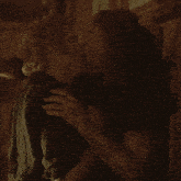 a man and a woman hugging each other in a dark room