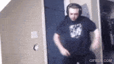 a man wearing headphones is dancing in a room with gifrun.com written on the bottom