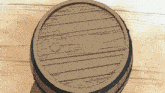 a wooden barrel with a hole in the middle sits on a wooden floor