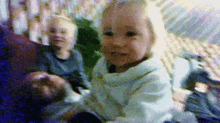 a little girl in a white sweater is sitting on a couch