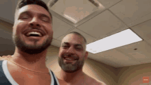 a man with a beard is laughing with another man in a room