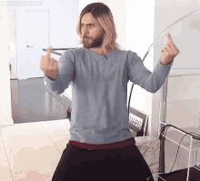 a man with a beard is giving the middle finger