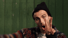 a man is making a funny face with his fingers