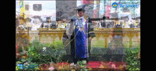 a man in a graduation cap and gown is standing on a stage with the words be strong behind him