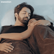 a man and a woman are hugging each other in bed with the words barunsobtigifs on the bottom