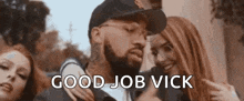 a man with a beard is standing next to two women and giving a thumbs up sign .