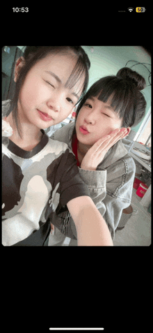 two girls are posing for a selfie with the time 10:53