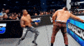 two men are wrestling in front of a crowd at a wrestling match .