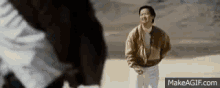 a man and a woman are standing next to each other in a desert .