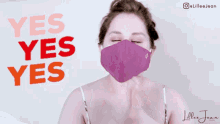 a woman wearing a purple face mask with the words yes yes yes behind her
