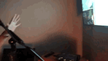 a person is playing a guitar in front of a television