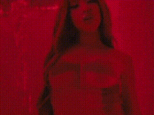 a woman is standing in a red room with a red background .