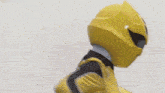 a man in a yellow superhero costume is standing in front of a white background .