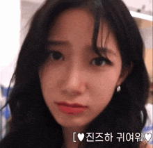 a close up of a woman 's face with korean writing behind her