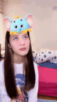 a woman wearing a blue elephant headband with a crown on it