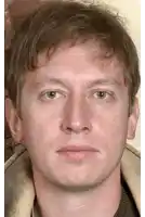 a close up of a man 's face with a sweater on