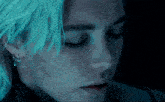 a close up of a woman 's face with blue hair and earrings