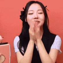a woman is making a funny face with her hands on her face .