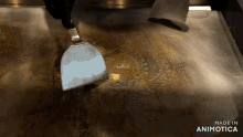 a spatula is being used to stir a piece of butter on a stove top