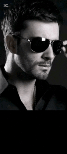 a black and white photo of a man wearing sunglasses and the name eli