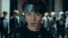 a man wearing a bandana on his head is standing in front of a crowd
