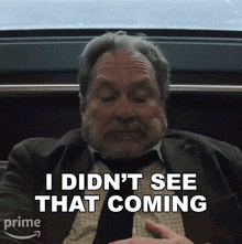 a man in a suit and tie is saying " i didn 't see that coming "
