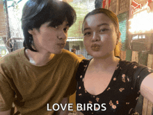 a man and a woman are posing for a selfie with the words love birds above them