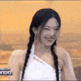 a woman with braids is smiling and laughing while wearing a white dress .
