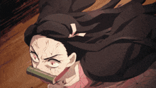 a close up of a cartoon character with red eyes and a book in her mouth