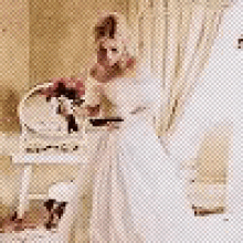 a woman in a white dress is standing in front of a dressing table .