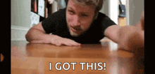 a man is laying on a wooden table and says `` i got this ! ''