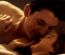 a man and a woman are kissing on a bed .