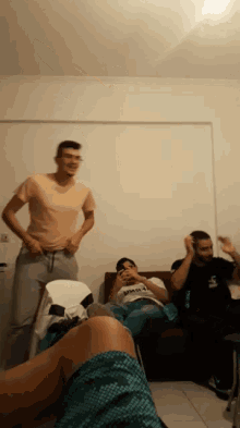 a man in a pink shirt is standing in a room with other people