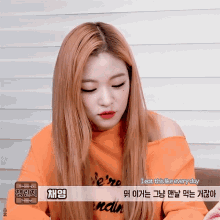a woman with long red hair is wearing an orange sweater that says " i eat this like every day "