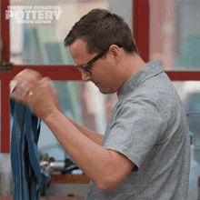 a man wearing glasses is working on a piece of pottery with the great canadian pottery throw down written above him