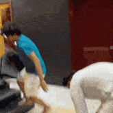 a man in a blue shirt and white shorts is bending over