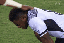 a man wearing a number 8 jersey is being patted on the head