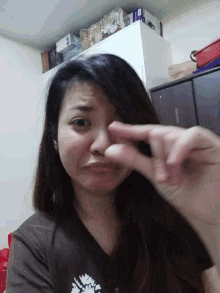 a woman making a peace sign in front of a fridge