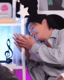 a man is laying down with his hands folded in front of a shelf