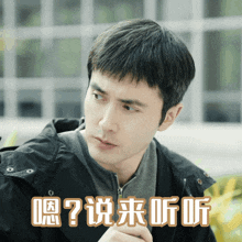 a man wearing a black jacket has chinese writing on his face