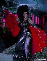 a drag queen is dancing in a dark room with purple lights behind her and the words t4yce tumblr at the bottom