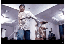 a man is dancing in a living room while holding a shoe .