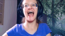 a woman wearing glasses and headphones is making a funny face .