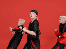 a group of young men are dancing in front of a red background and one of their shirts has the word nissan on it