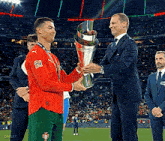 a man in a suit is shaking hands with a soccer player