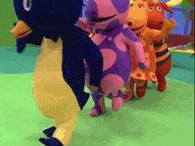 a group of stuffed animals are dancing together on a green field .