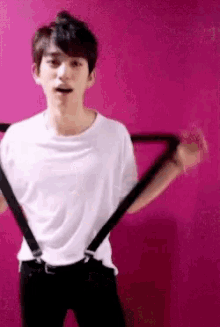 a young man is wearing suspenders and a white shirt .